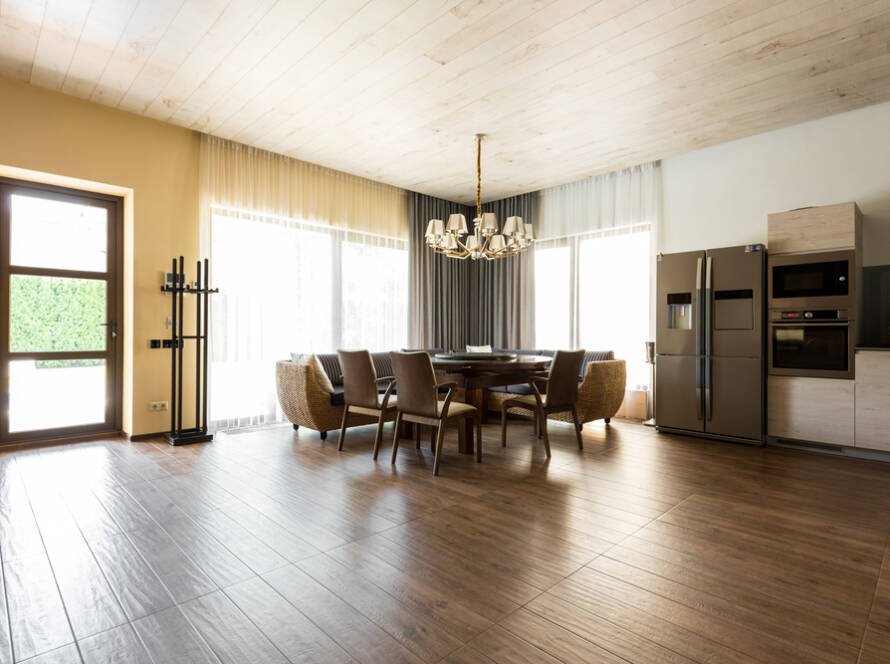 Vue intérieure d’une cuisine moderne ouverte sur la salle à manger, avec table et chaises.